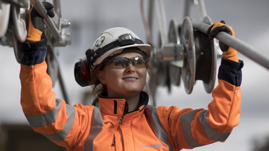 Female engineer wearing PPE holding National Grid high-voltage power cables